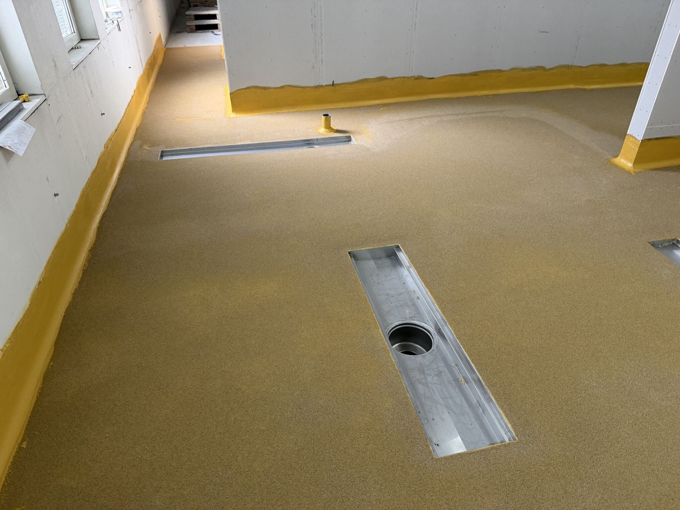 Sol de cuisine professionnelle jaune avec évacuations au sol chez Hotell Månen